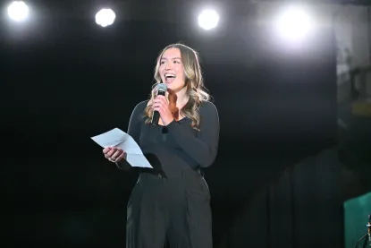 A student on stage with a microphone presenting