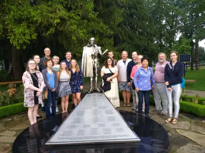 A group of students and faculty gather around the Shakespeare statue in Stratford, Ontario.