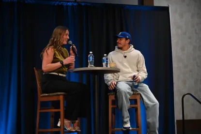 A student sits on stage with actor Tony Ramos.