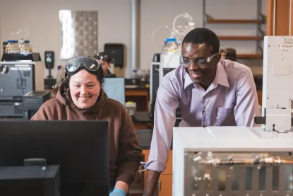Professor helping student in chemistry lab