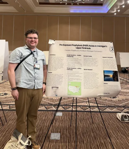 A student stands next to a poster.