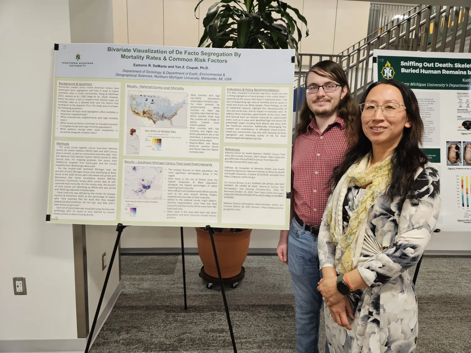 A female professor and her student in front of a poster