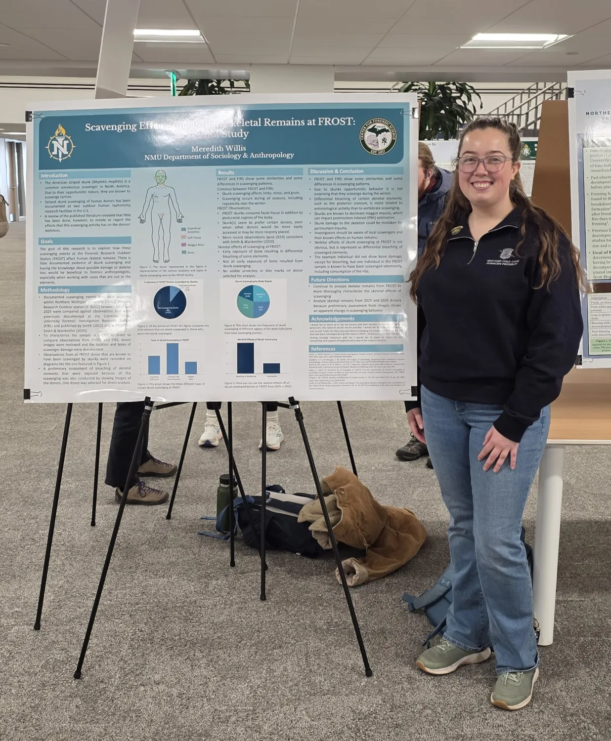 A female student standing next to a poster