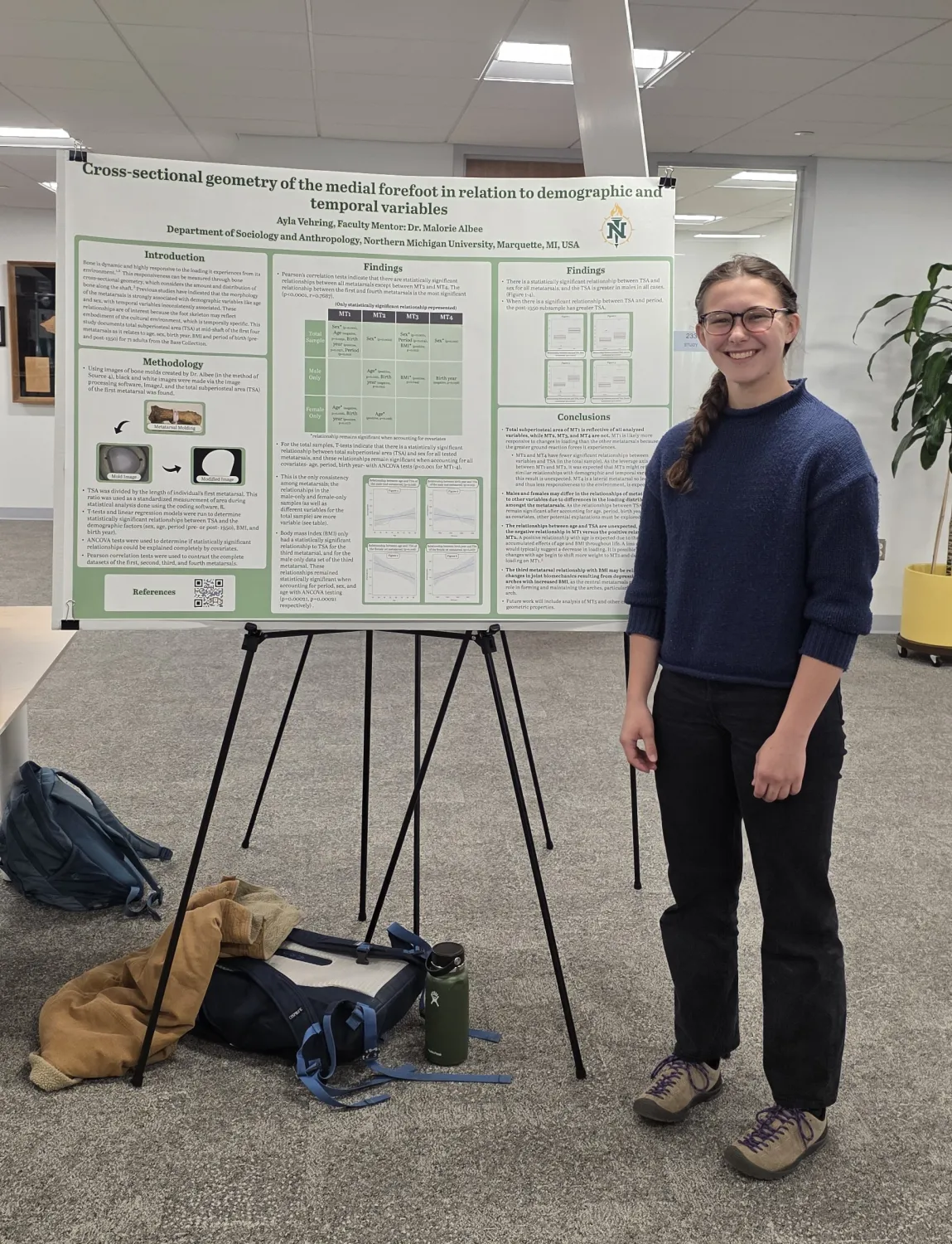 A female student standing next to a poster