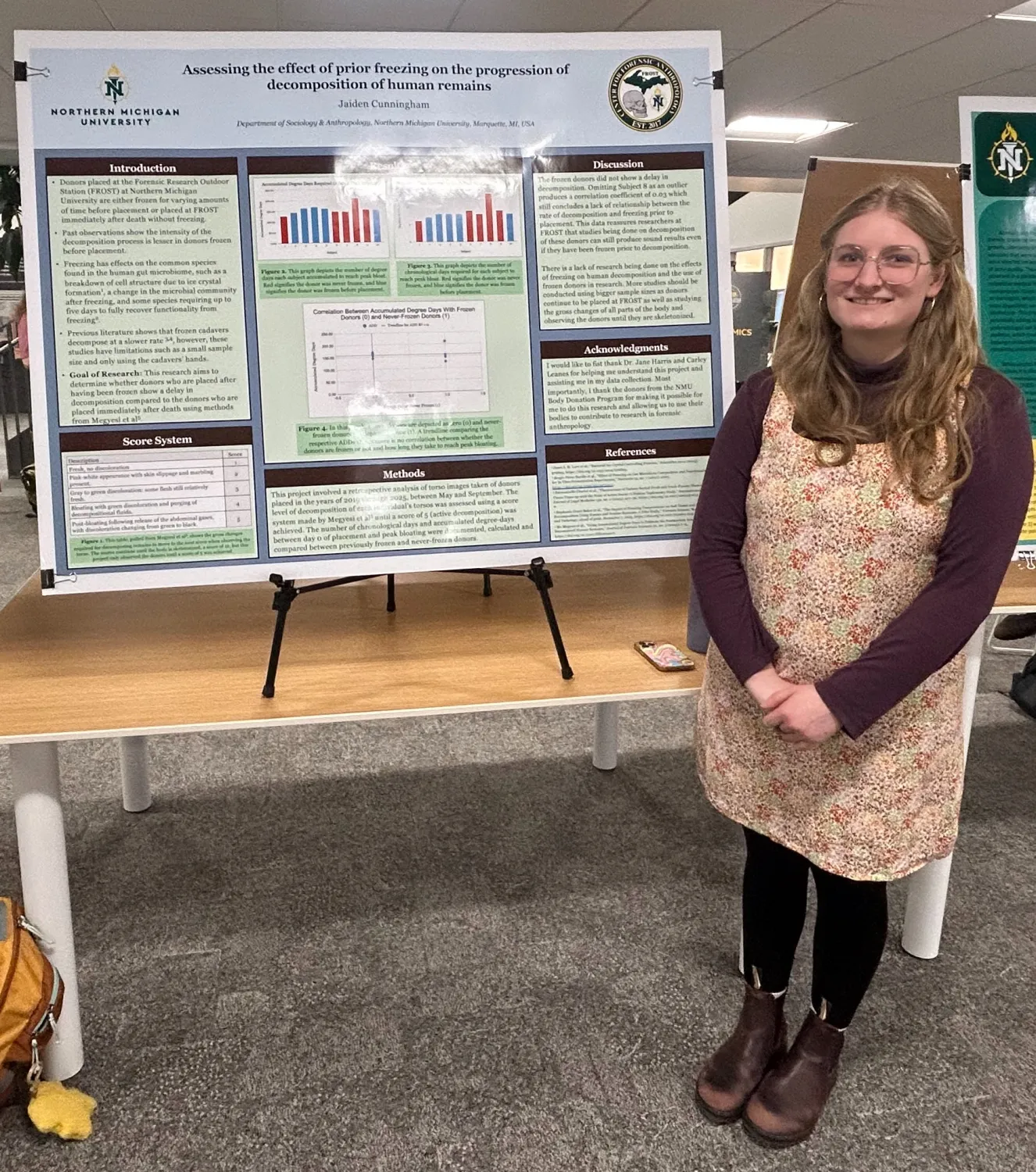 A female student standing next to a poster