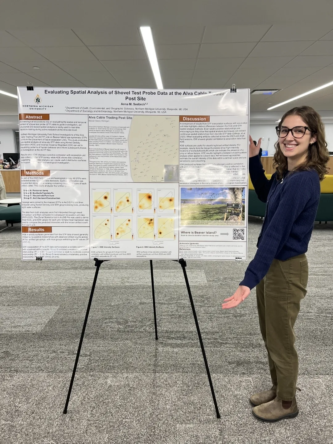 A female student standing next to a poster