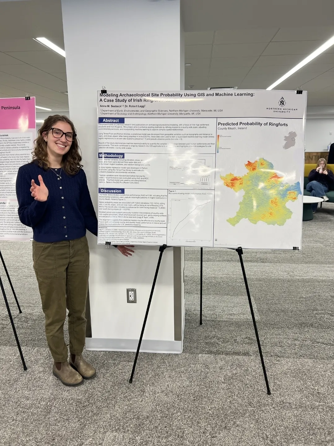 A female student standing next to a poster