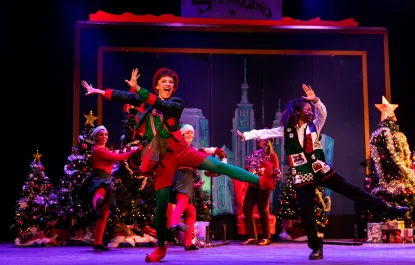 Students dance onstage during a performance of ELF THE MUSICAL