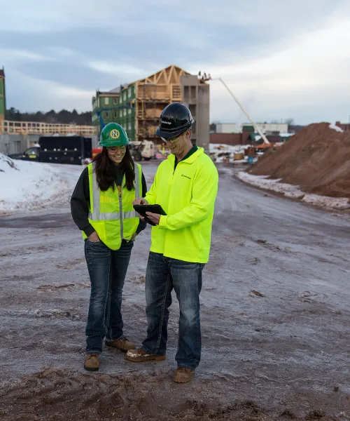 Two construction management students talking at a construction site