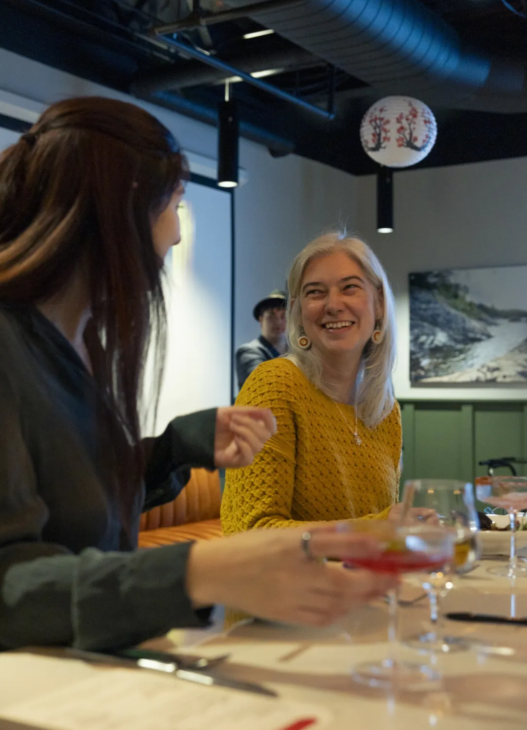 Two guests laugh at the bar during an event