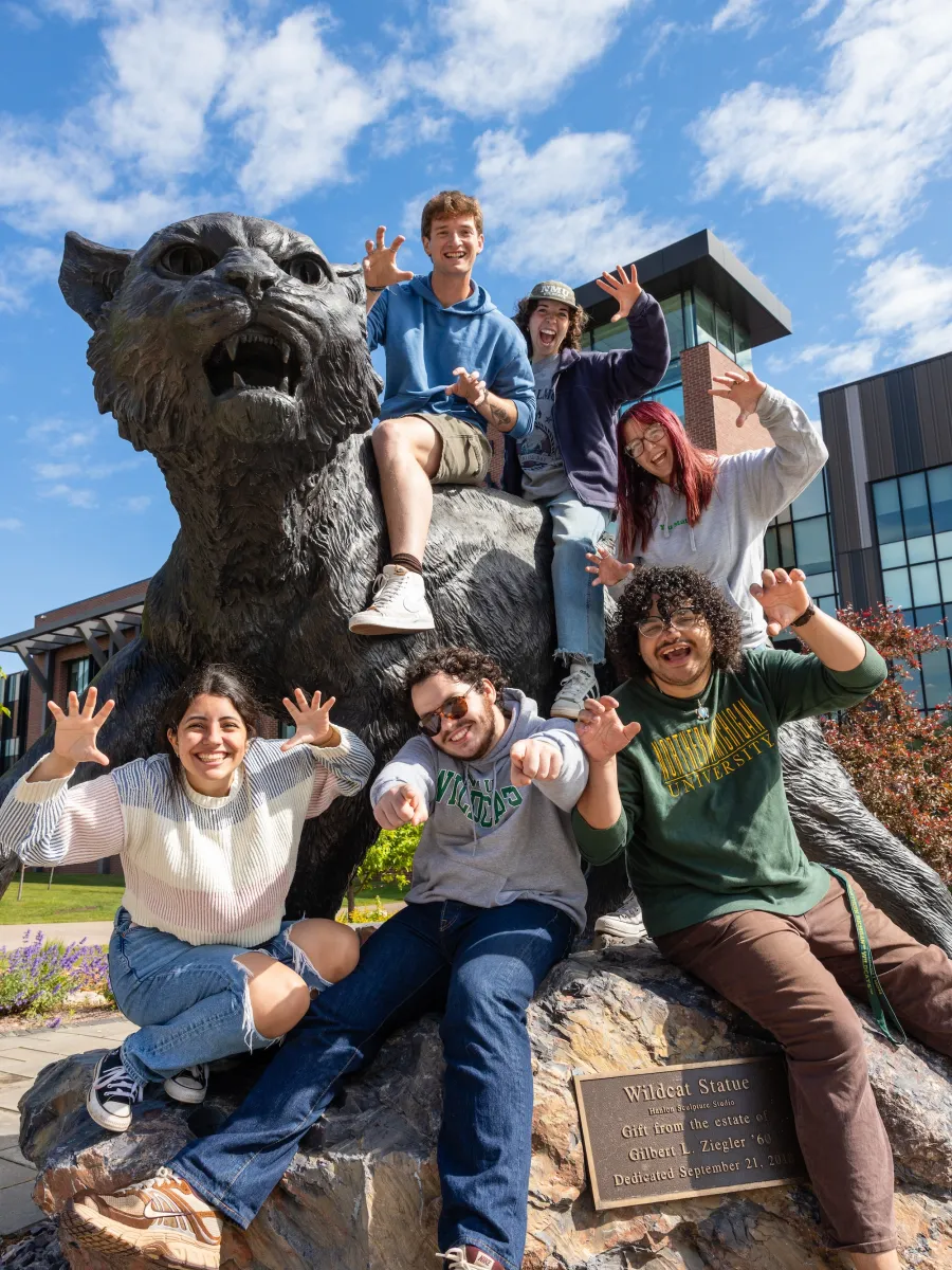 Group of students at the Wildcat Statue on NMU's campus