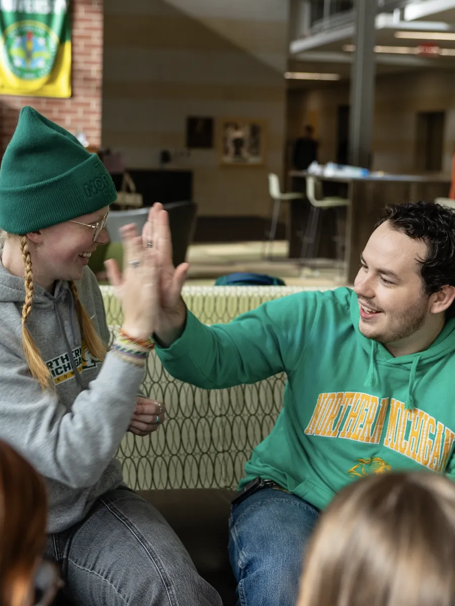 Two Northern Michigan University students high fiving 