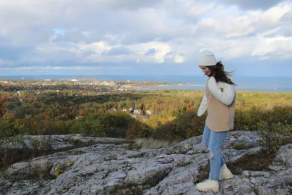 Liz Preston standing at the top of Sugarloaf Mountain in Marquette, Michigan.
