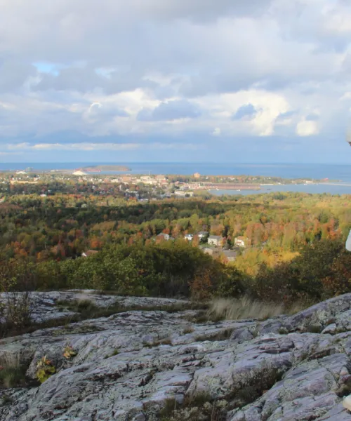 Student standing at the top of Sugarloaf Mountain in Marquette, Michigan.