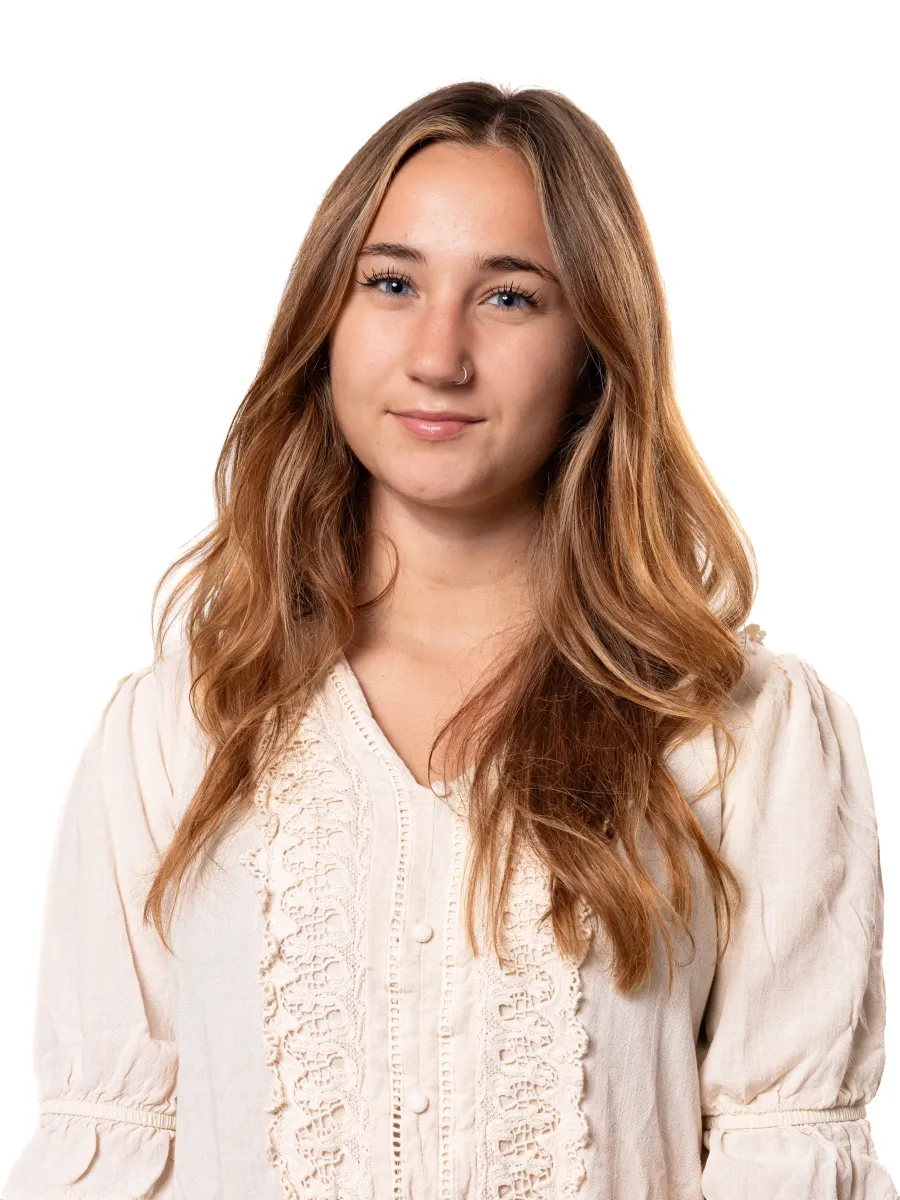 Headshot of student wearing white ivory top. She has brown highlighted hair.