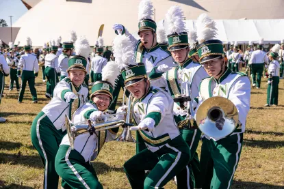 Six NMU band members posing in front of the Superior Dome
